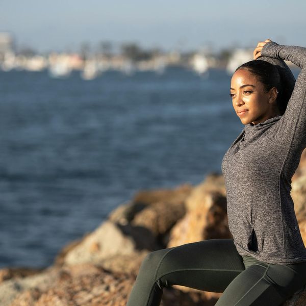 Person stretching outdoors during sunrise feeling refreshed and energetic.